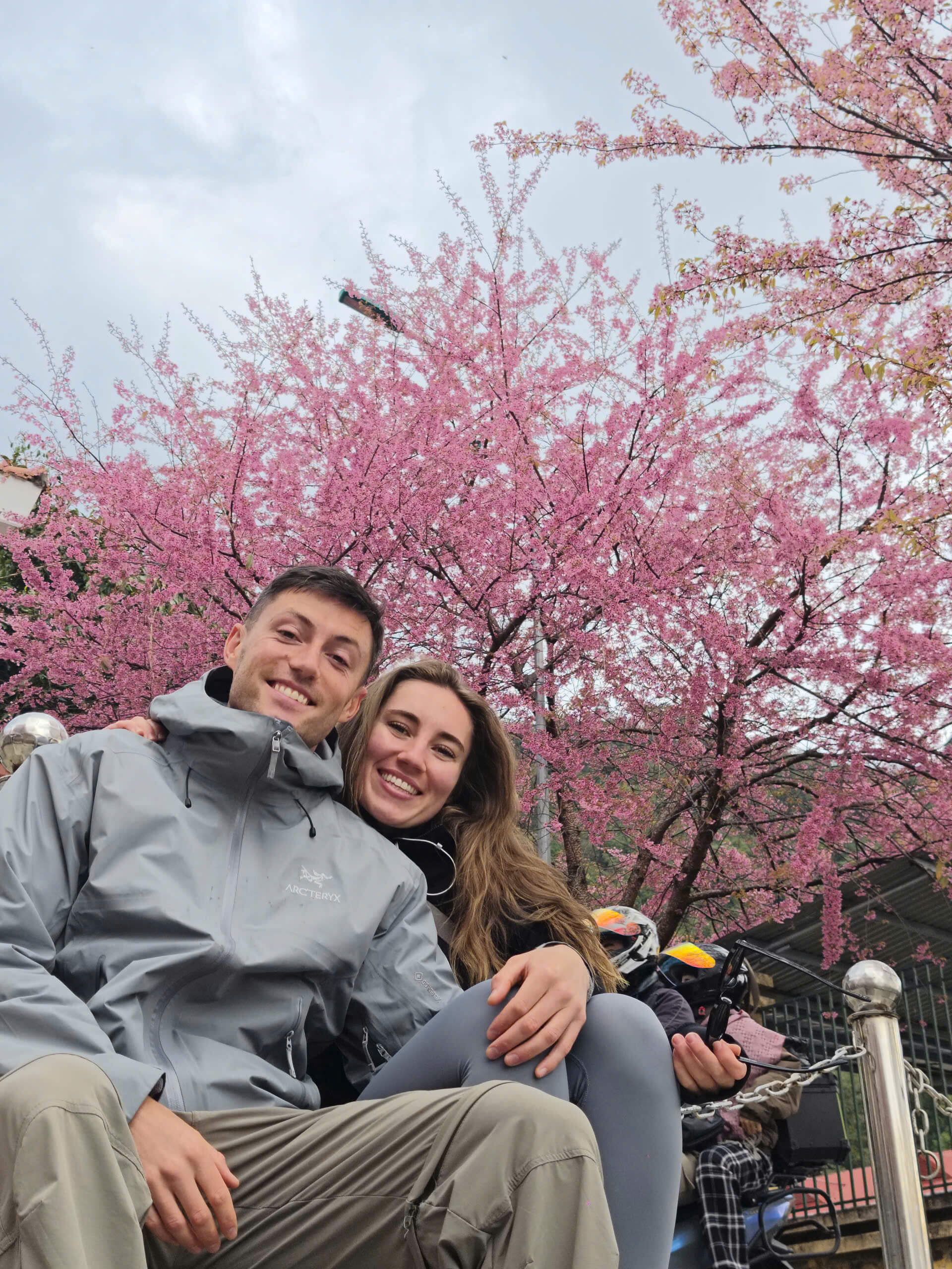 Motorbike travelers stopping for a photo during their 4-day Ha Giang Loop itinerary in the blossom season.
