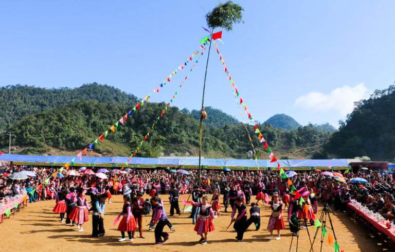 Hmong ethnic men playing the Khen instrument while women perform a traditional umbrella dance at Ha Giang Festival 2026.